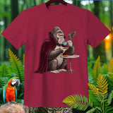 Gorilla in vampire cape drinking coffee with a bat at a table.