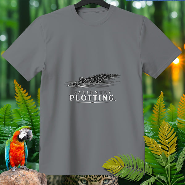 Gray t-shirt with black graphic of an alligator in water, text "Patiently Plotting."