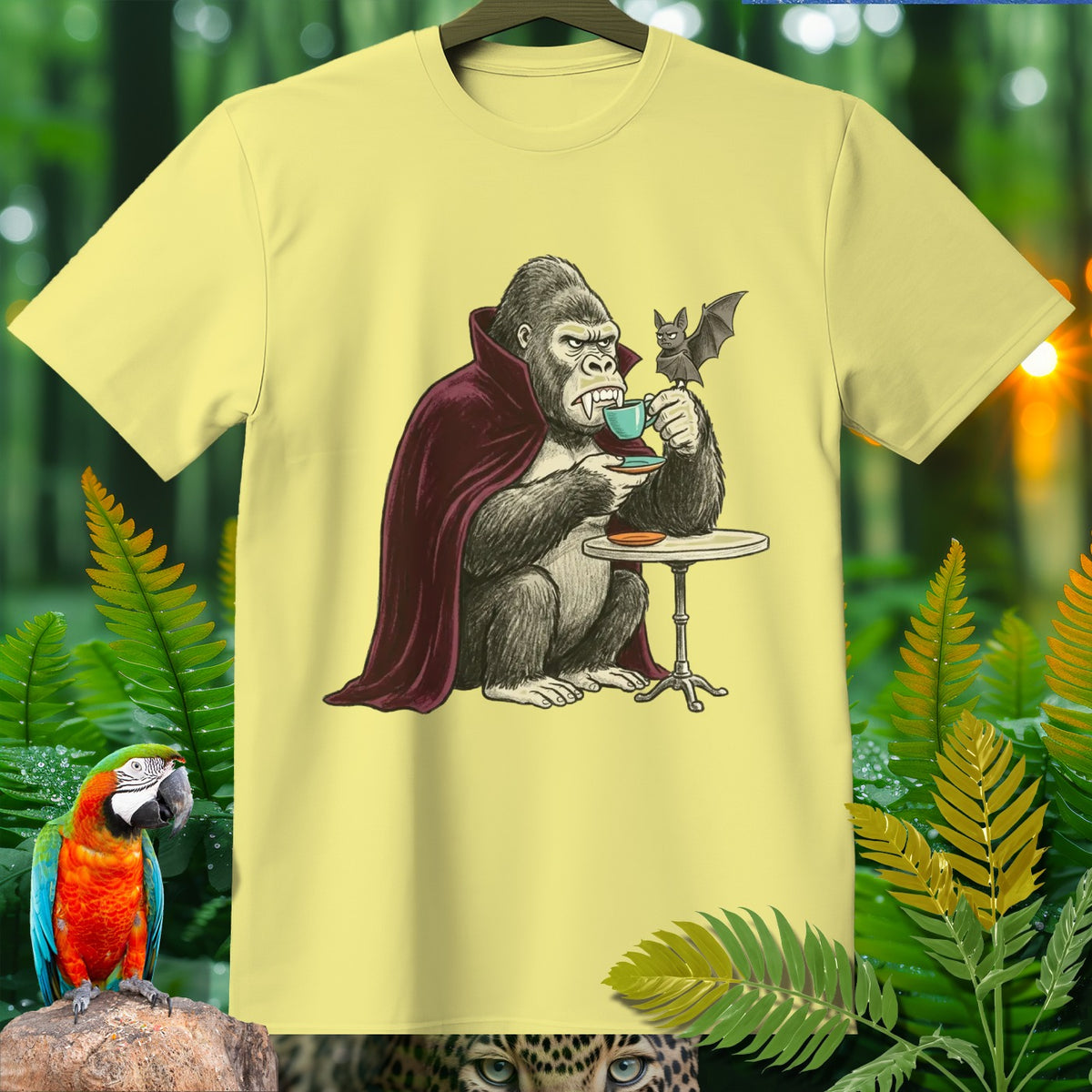 Gorilla in vampire cape drinking coffee with bat on a light yellow t-shirt.