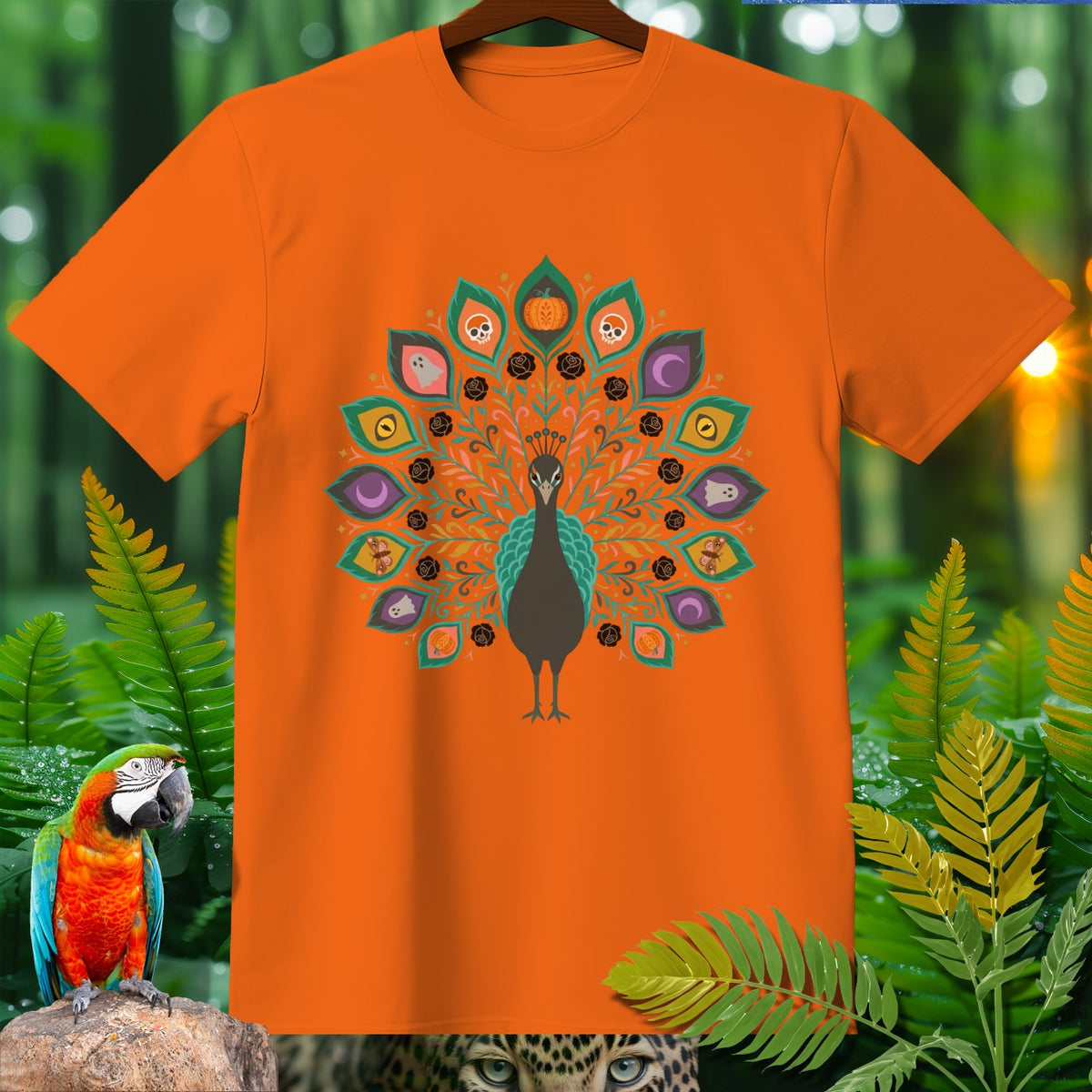 Orange t-shirt with a peacock design featuring Halloween motifs.