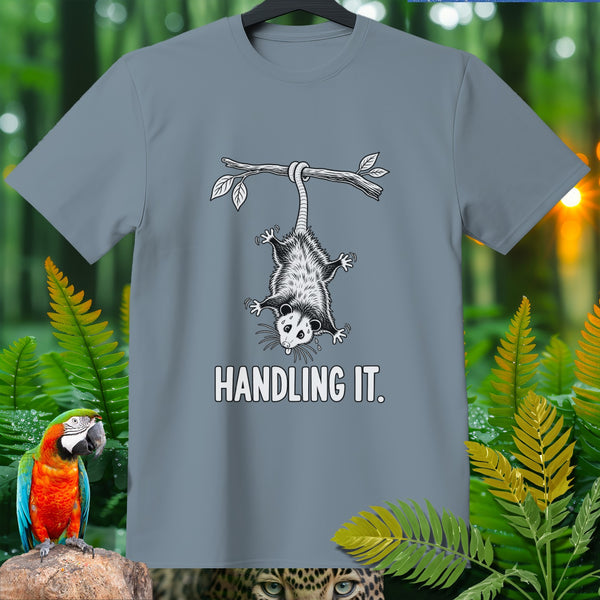Gray t-shirt with opossum hanging from a branch, text "HANDLING IT."