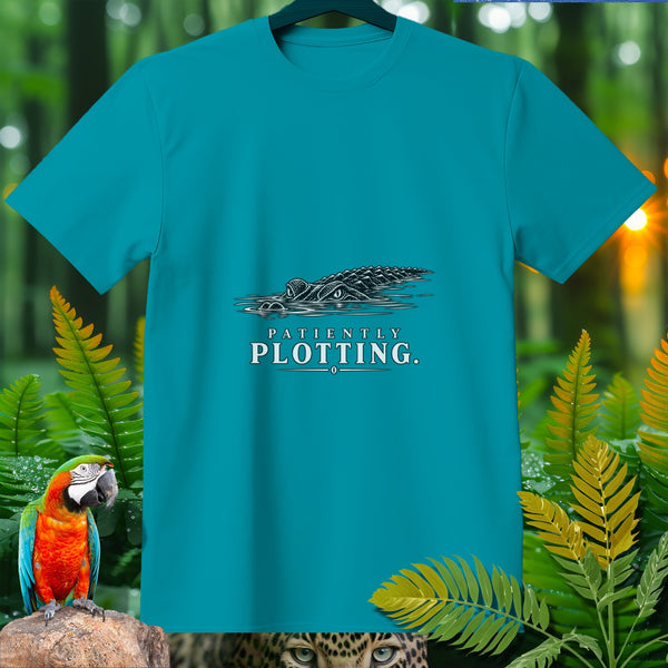 Teal t-shirt with alligator graphic and text "PATIENTLY PLOTTING."