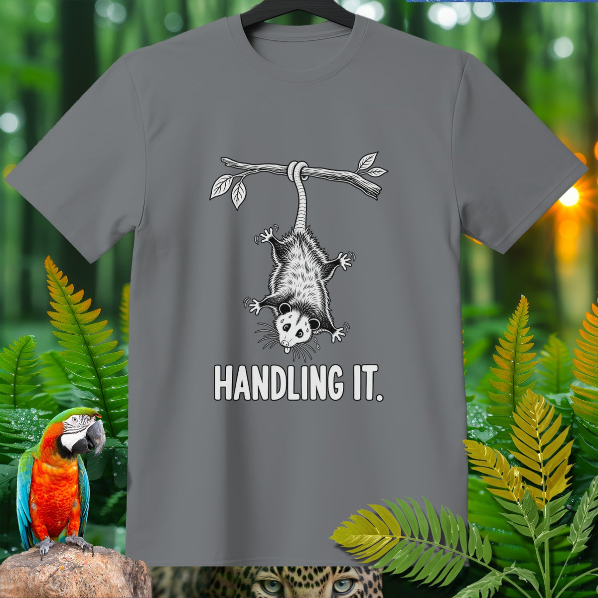 Grey t-shirt with opossum hanging from a branch, text "HANDLING IT.".