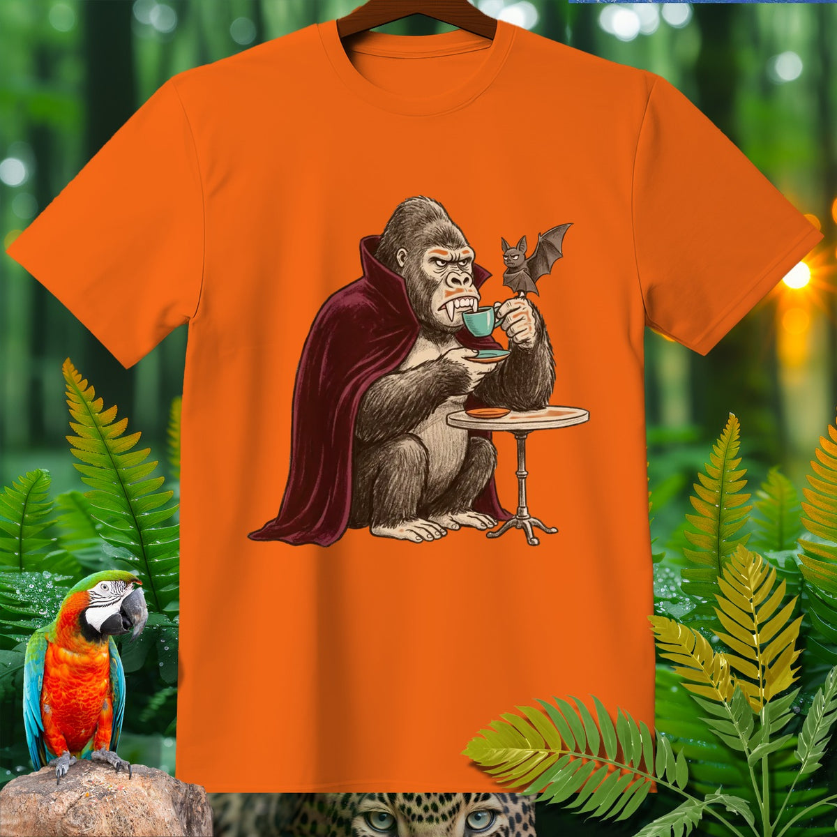 Gorilla in vampire cloak drinking tea with a bat, on an orange t-shirt.