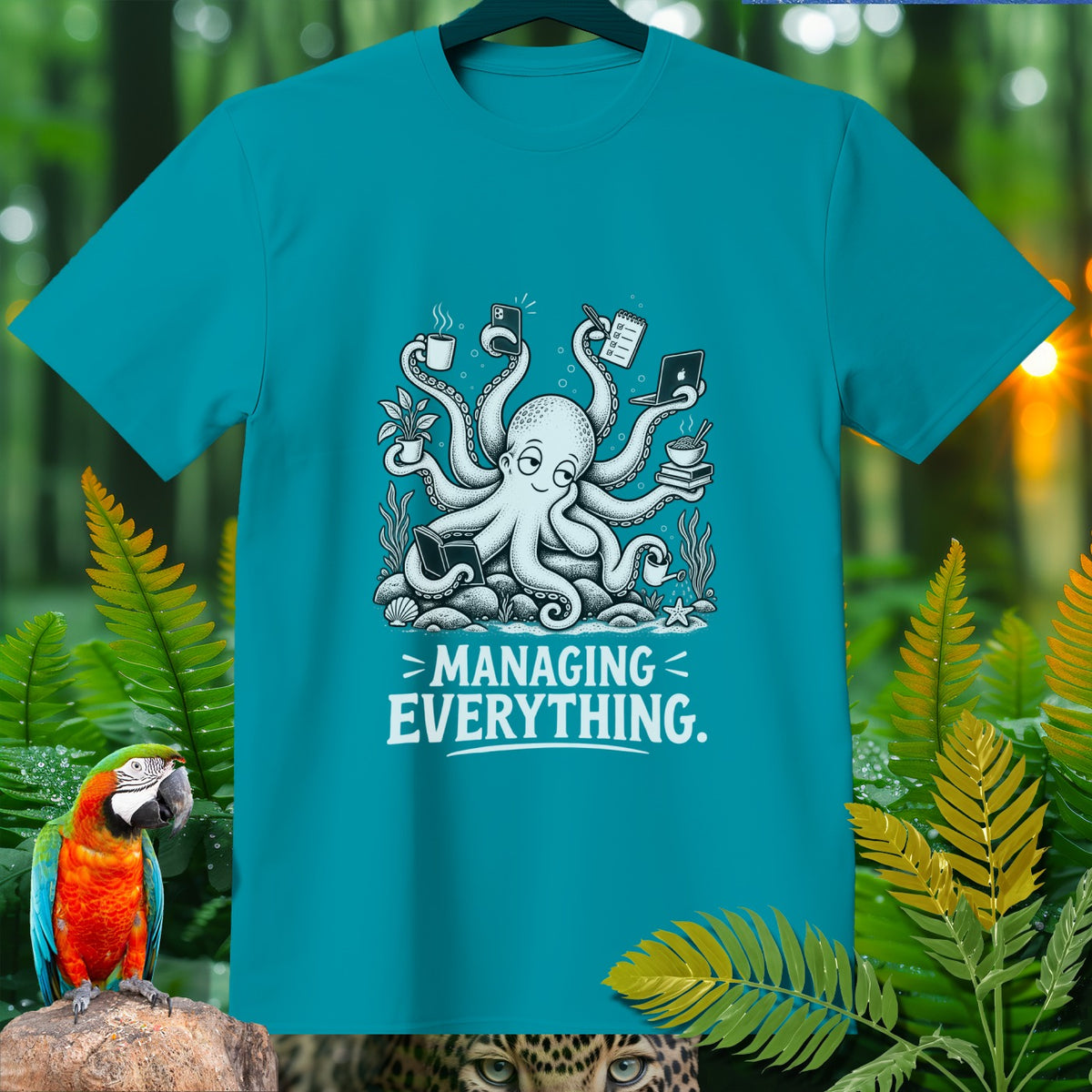 Teal t-shirt with a cartoon octopus managing multiple tasks and coffee, text reads "MANAGING EVERYTHING."