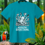 Teal t-shirt with a cartoon octopus managing multiple tasks and coffee, text reads 