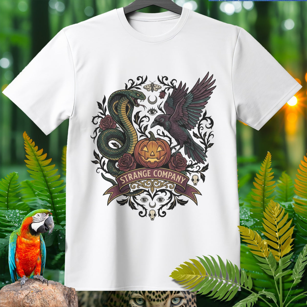White t-shirt with dark gothic art featuring snake, raven, pumpkin, roses, and banner reading "STRANGE COMPANY".