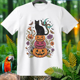 Black cat sits on stacked Halloween pumpkins with snakes, moons, and flowers.