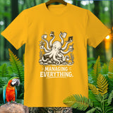Yellow t-shirt with a cartoon octopus juggling coffee, phone, laptop, and books, text 