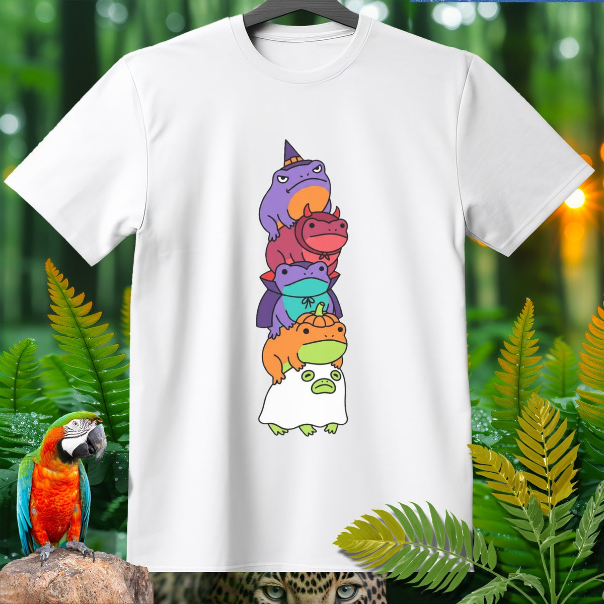 White t-shirt with stack of five cartoon frogs in Halloween costumes.
