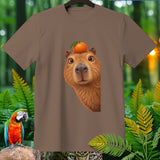 Brown t-shirt with a capybara wearing a small orange on its head.