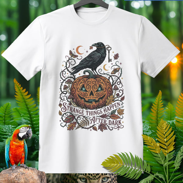 White t-shirt with Halloween design featuring raven, pumpkin, key, and text "STRANGE THINGS HAPPEN AFTER DARK".