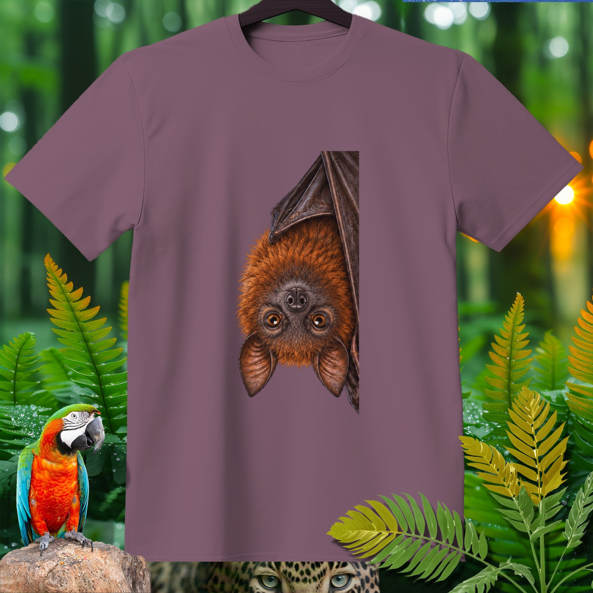 T-shirt with a bat print hanging upside down, surrounded by foliage.
